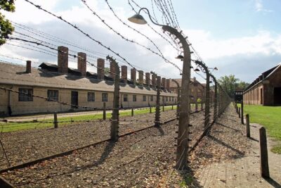 Full-Day Auschwitz and Birkenau Tour from Krakow with Private Transfer - Entering Auschwitz I: the gate, barracks, and the International Victims monument